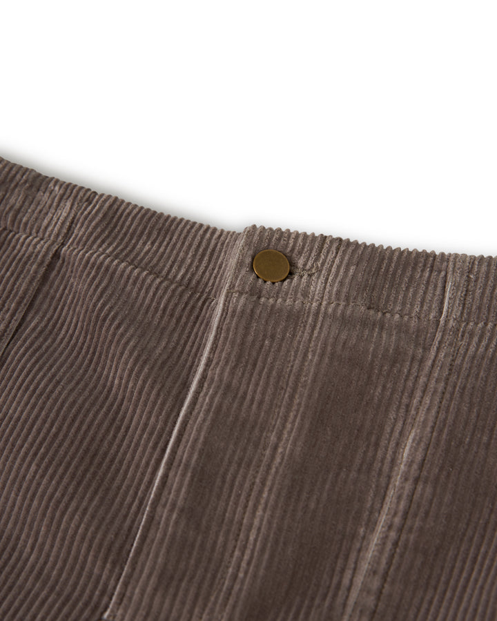 Close-up of The Corsica Corduroy Short in Argento by Dandy Del Mar, featuring a brown corduroy fabric with a brass button on the waistband.