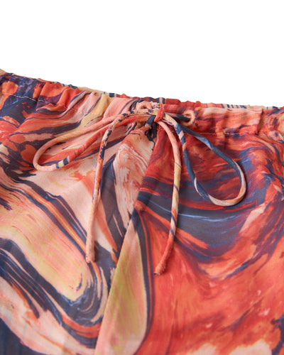 Close-up of The Curacao Shorts - Lantana by Dandy Del Mar, showcasing colorful marbled chiffon, an elastic waistband, and a drawstring bow for a relaxed fit.
