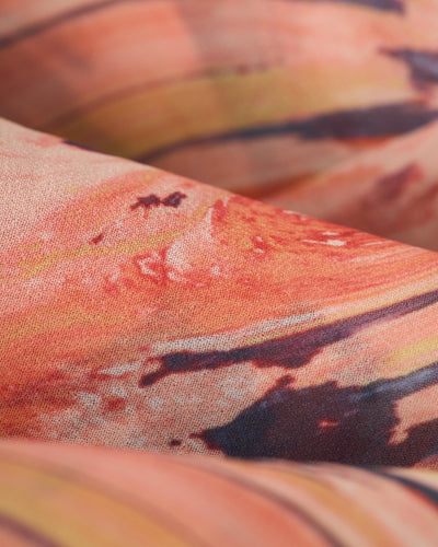 Close-up of The Curacao Shorts - Lantana by Dandy Del Mar, featuring an abstract orange, yellow, and black pattern with visible texture, soft folds, and a relaxed fit.