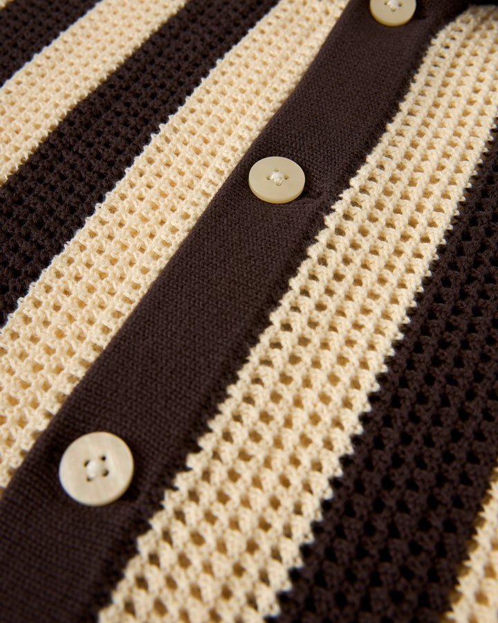 Close-up of The Dominica Crochet Shirt - Tierra by Dandy Del Mar, featuring a crochet fabric with vertical beige and brown stripes and beige buttons.