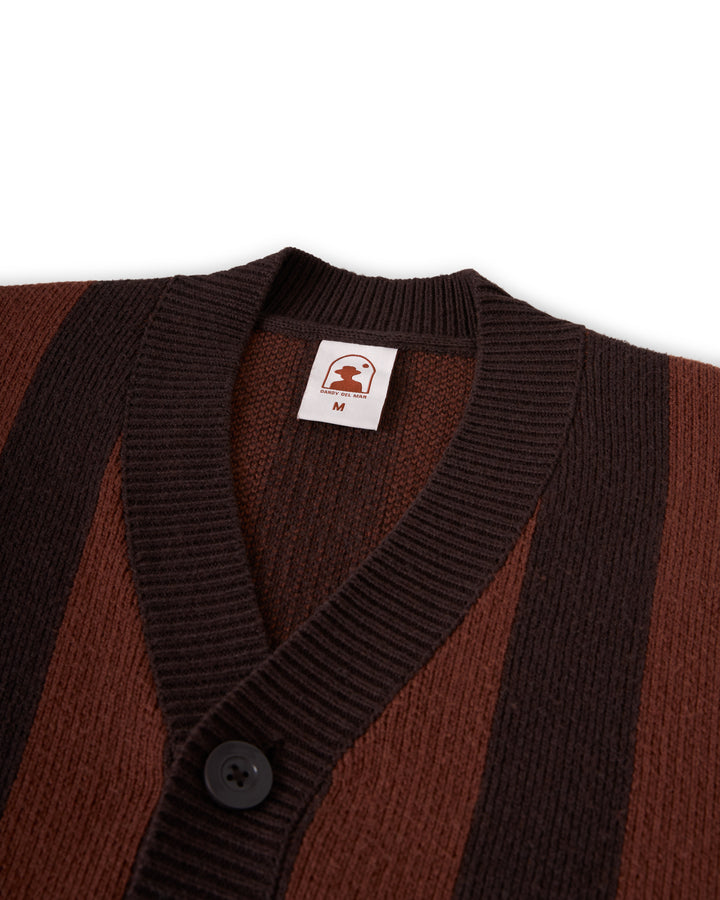 A close-up of the luxury Florence Knit Cardigan - Garam by Dandy Del Mar, highlighting its elegant brown and black jacquard knit stripes, adorned with a button and featuring a label with the logo and size "M".