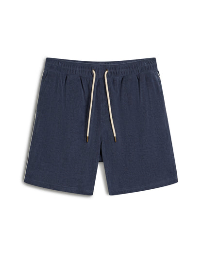 The Gaucho Short - Moontide by Dandy Del Mar are cozy terry cloth athletic shorts in dark blue, featuring an elastic waistband and white drawstrings, displayed on a white background.