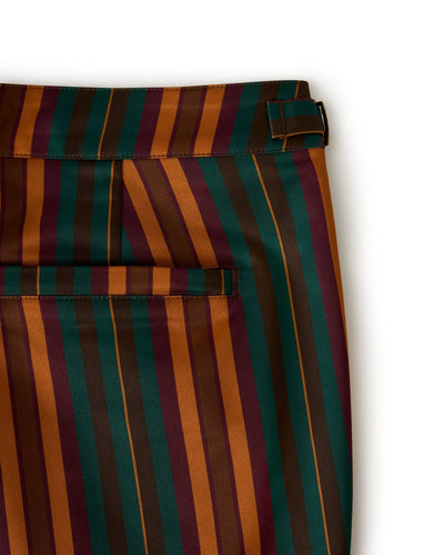 Close-up of Dandy Del Mar's Mallorca Swim-Walk Shorts in Burnt Sienna, showing vertical stripes in brown, green, and burgundy with a waistband, adjustable side fasteners, and back pocket.