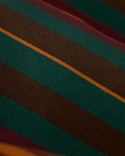 Close-up of Dandy Del Mar's The Mallorca Swim-Walk Shorts - Burnt Sienna, featuring horizontal stripes in green, brown, maroon, and yellow on woven nylon fabric. Adjustable side fasteners ensure a perfect fit.