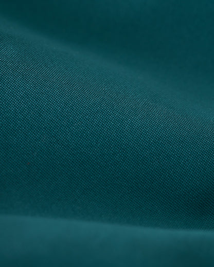 Close-up of a teal fabric with fine texture and visible weave pattern, akin to the high-quality construction of Dandy Del Mar’s Mallorca Swim-Walk Short in Tempest Blue.