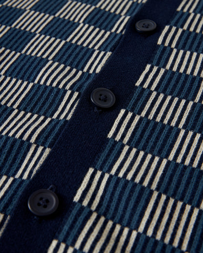 Close-up image of The Martinique Sweater-Knit Shirt - Anchor by Dandy Del Mar, showcasing its blue and white checkered fabric complemented by a vertical ribbed button placket adorned with black buttons.