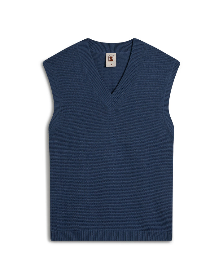 The Montego Knit Vest - Moontide by Dandy Del Mar is a blue sleeveless sweater with a V-neck design, displayed on a white background.