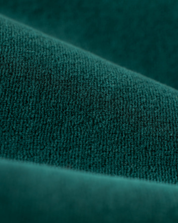 Close-up image of green textured fabric folds, reminiscent of the luxurious Rio Velour Jacket - Albero by Dandy Del Mar, showing a detailed view of the material's fibers and surface.