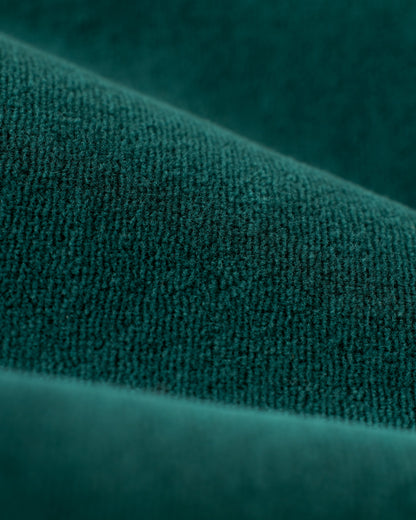 Close-up image of a deep green, textured fabric with visible folds and a plush surface, reminiscent of Dandy Del Mar's The Rio Velour Pant - Albero, perfect for athletic leisure.