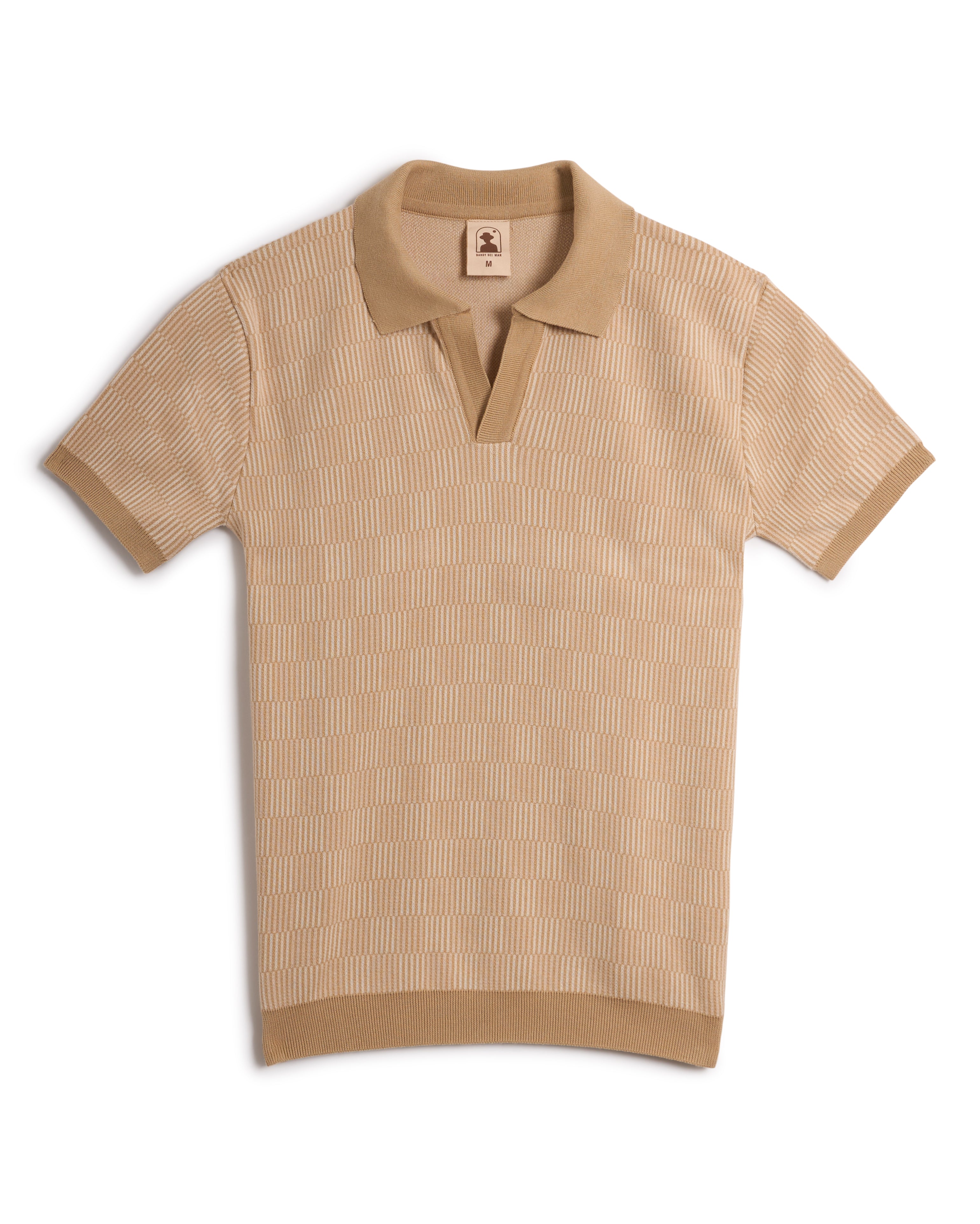 Introducing The Sebastian Knit Polo - Shell by Dandy Del Mar: a beige short-sleeve, buttonless polo with an elegant texture, refined collar, and subtle logo tag. Experience Italian knitwear luxury in every stitch.