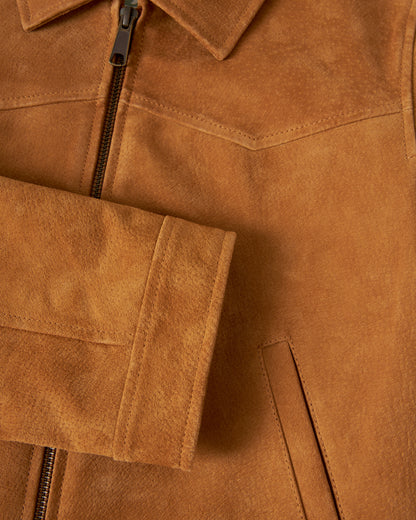 Close-up of The Sicily Leather Jacket - Sable by Dandy Del Mar, showcasing its sleek zipper, stylish collar, and a prominently visible pocket adorned with neat stitching. The texture of the luxurious brown suede and the refined leather finish are clearly displayed.