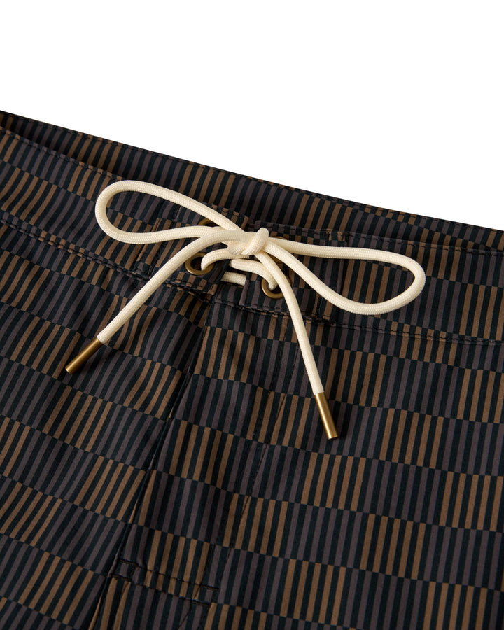 Close-up of The Stirata Swim Short - Onyx by Dandy Del Mar featuring a black and brown striped pattern with a white drawstring waist tie.