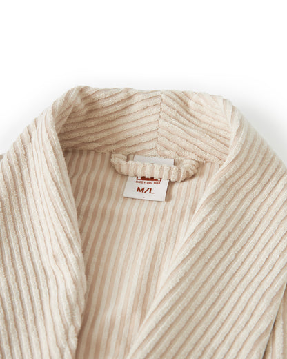 Close-up of The Tropez Jacquard Robe - Scallop Stripe by Dandy Del Mar, showcasing its cream-colored, ribbed bathrobe collar with a visible size tag indicating M/L. The jacquard striped terry cloth adds an elegant touch to the luxurious fabric.