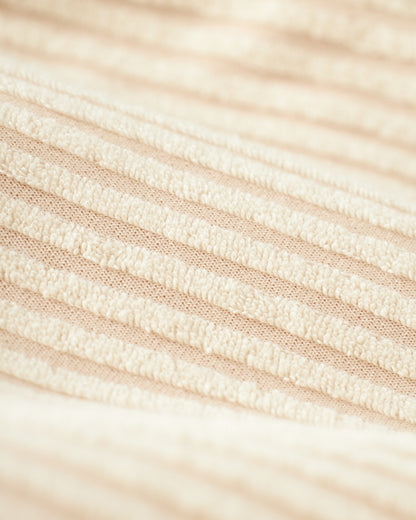 Close-up of the beige jacquard fabric with scallop stripes and horizontal ridges, reminiscent of the luxurious textures found in The Tropez Jacquard Shirt by Dandy Del Mar.