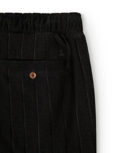 Close-up of The Tropez Jacquard Shorts - Onyx by Dandy Del Mar, featuring black jacquard stripes, an elastic waistband, and a back pocket with a brown button—ideal for luxe lounging.