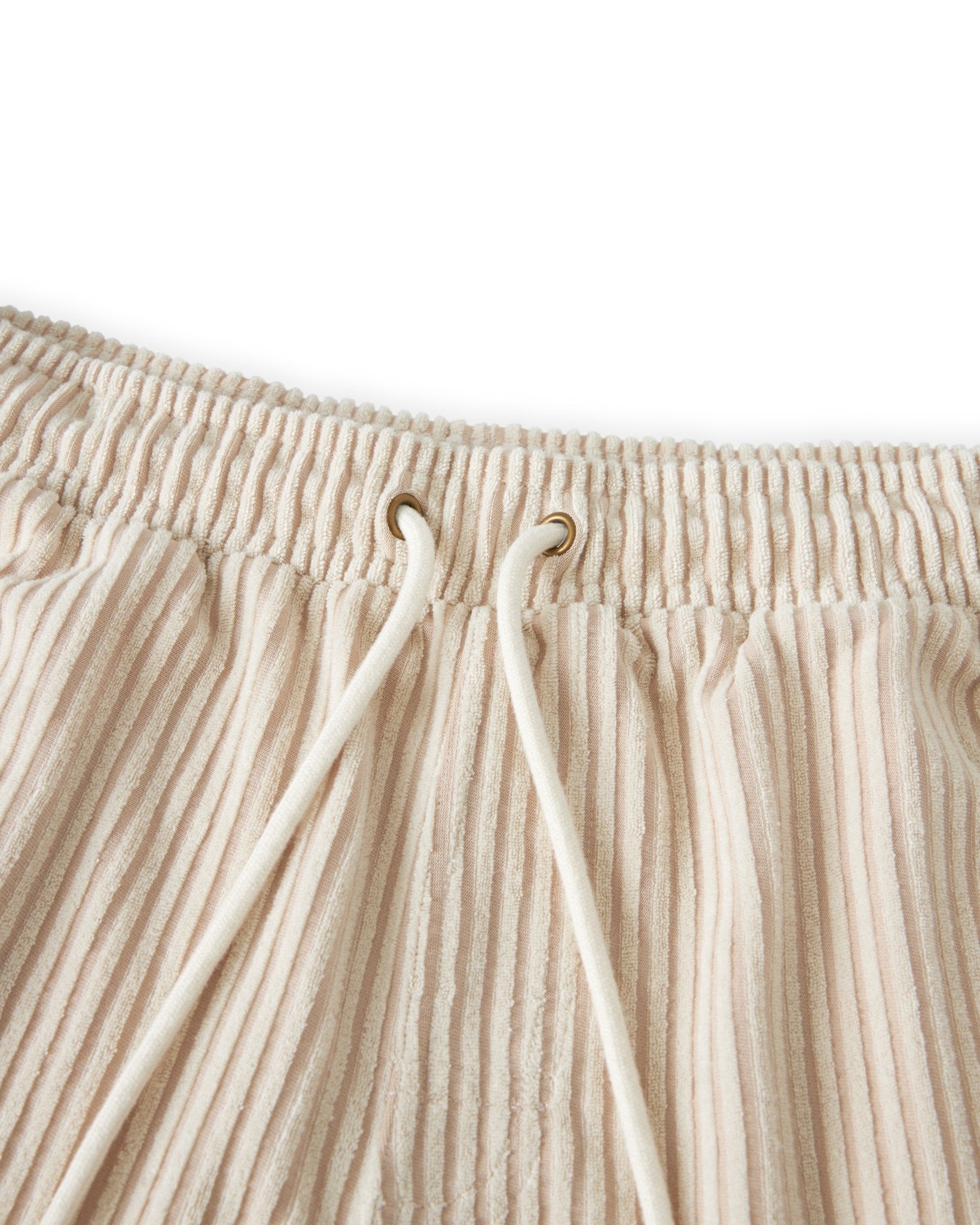 Close-up of The Tropez Jacquard Shorts - Scallop Stripe by Dandy Del Mar, featuring beige ribbed jacquard terry cloth, an elastic waistband, and cream drawstrings for a cozy lounge look.