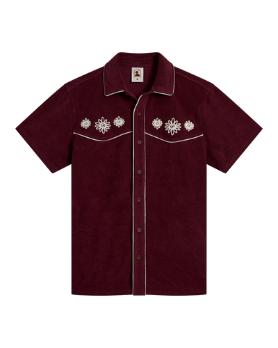The Gaucho Terry Cloth Shirt - Bordeaux by Dandy Del Mar, a short-sleeve maroon shirt with white piping and floral chest embroidery, shown on a white background.