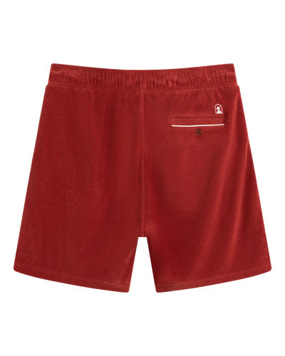 Back view of The Gaucho Terry Cloth Shorts - Rouge by Dandy Del Mar, featuring an elastic waistband, single buttoned back pocket, and small white embroidered logo above the pocket.