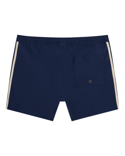 The Ventura Volley Shorts - Anchor by Dandy Del Mar offer style and comfort with a navy blue design, elastic waistband, white side stripes, and a back pocket with metal grommet—essential men’s swimwear for beach or pool days.