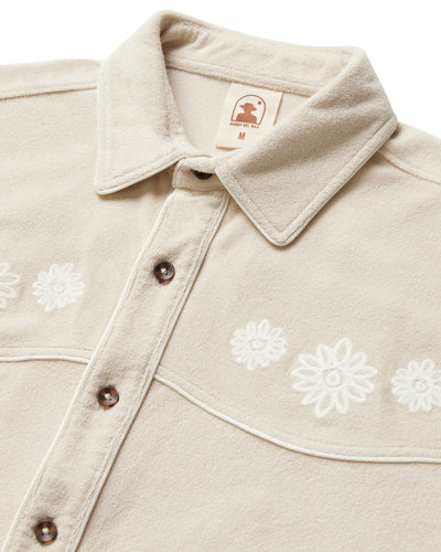 The Dandy Del Mar Gaucho Terry Cloth Shirt in Alabaster features white floral embroidery and a pointed collar, shown from the chest up.